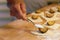 Preparation of homemade fruit dumplings with plums. Czech specialty of sweet good food. Dough on kitchen wooden table with hands