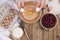 Preparation of homemade sweet pastries with cherries. Eggs, flour and berries on a wooden background. Female hands split eggs.