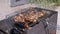 Preparation of Juicy Meat on a Grill, Barbecue in a Backyard in Rays of Sunlight