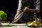 Preparation of mackerel by the chef, on a black background with lemons, limes