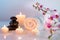 Preparation for massage in white with towels, stones, candles and orchid