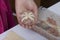 Preparation of meat glomeruli. Stuffed turkey, wrapped in strips of puff pastry. A woman winds a strip of dough on a meat ball