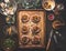 Preparation of minced meat patties in bagel shape filled with roasted vegetables on baking sheet on rustic kitchen table with