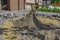 Preparation of mortar for the repair of granite pavers near a private house. Mixing a heap of dry cement-sand mix with a shovel