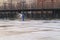 Preparation for outdoor sport activity: male worker pour water at ice rink, skating rink for hockey