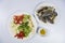 Preparation with raw crab, lemon, onion, pepper, tomato, herbs and spices on white plate, top view, Sea food.