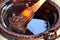 Preparation of red mole, a typical Mexican dish in a clay pot with a giant wooden spoon over the fire of a stove with all the inte