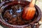 Preparation of red mole, a typical Mexican dish in a clay pot with a giant wooden spoon over the fire of a stove with all the inte