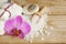 Preparation for spa treatments, salt, towels, lotion and a bright orchid flower on a wooden table