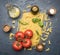 Preparation of spaghetti with tomatoes, basil, butter, various seasonings, rich in carbohydrates lunch, on rustic dark blue backgr