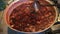 Preparation of strawberry jam.Varit jam. A woman`s hand with a ladle neatly stirs the berry homemade jam. Traditional cuisine