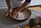 Preparation, Thanksgiving Day celebration. The cook puts the dough into an iron mold. Evens the dough with her hands. Nearby on