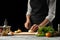 Preparation of tomato sauce by the hands of the chef, steps the process in the kitchen on a black background copy the text of the