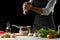 Preparation of tomato sauce by the hands of the chef, steps the process in the kitchen on a black background copy the text of the