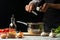 Preparation of tomato sauce by the hands of the chef, steps the process in the kitchen on a black background copy the text of the