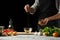 Preparation of tomato sauce by the hands of the chef, steps the process in the kitchen on a black background copy the text of the