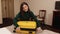 Preparation travel suitcase at home. Open trendy yellow handbag on bed. Open