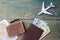 Preparation for Traveling concept. Money, passport, airplane, suitcase and map on a vintage wooden background.