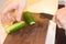 Preparation of vegetable salad. Close-up of a man& x27;s hand with a knife chopped cucumber