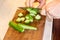 Preparation of vegetable salad. Close-up of a man& x27;s hand with a knife chopped cucumber