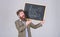 Prepare for new school year. Teacher bearded man stands and holds blackboard inscription back to school grey background