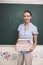 Prepared for an exciting lesson. Portrait of a pretty teacher carrying a large stack of books in her classroom.