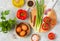 Prepared ingredients for cooking shakshuka, fried eggs with tomato stew on a gray concrete background. Hearty breakfast recipes