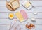 Prepared ingredients for making a hot croque madame sandwich on a white wooden background. Recipes for sandwiches, hot breakfasts