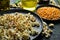 Prepared popcorn in frying pan, corn seeds in bowl and corncobs on kitchen table.