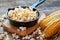 Prepared popcorn in frying pan, corn seeds and corncobs