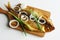 Prepared smoked Baikal omul on a natural oak cutting board next to green and onion on a white background. A rare fish delicacy