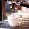 Prepares espresso in his coffee shop; close-up