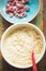 Preparing avocado, lime cake with berries. Cake dough with raspberries in bowl with spoon.