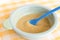 Preparing baby food, homemade.Top view of a bowl with smashed banana mixed with breast milk in a blue bowl on a tablecloth.