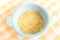 Preparing baby food, homemade.Top view of a bowl with smashed banana mixed with breast milk in a blue bowl on a tablecloth.