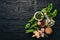 Preparing basil pesto sauce. Basil, parmesan cheese, olive oil. Top view. On a black wooden background.