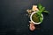 Preparing basil pesto sauce. Basil, parmesan cheese, olive oil. Top view. On a black wooden background.