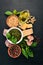 Preparing basil pesto sauce. Basil, parmesan cheese, olive oil. Top view. On a black wooden background.