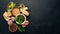 Preparing basil pesto sauce. Basil, parmesan cheese, olive oil. Top view. On a black wooden background.