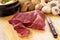 Preparing beef for casserole or stew with ingredients and knife on kitchen chopping board