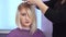 Preparing a blonde for a haircut. Woman getting new haircut by hairdresser at beauty salon. polishing hair