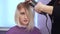 Preparing a blonde for a haircut. Woman getting new haircut by hairdresser at beauty salon. polishing hair