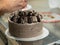 preparing brown frosted icing cup cake with cookies on top