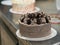 preparing brown frosted icing cup cake with cookies on top