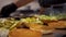 Preparing burgers in a fast food restaurant. Close up view of a fast food worker adding vegetables to the burger