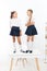 Preparing children for future. Happy little schoolgirls standing on table in classroom. Going together towards a