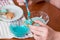 Preparing for Christmas, decorating traditional gingerbread with multicolored sugar glaze, the girl folds the cookies in a white