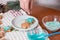 Preparing for Christmas, decorating traditional gingerbread with multicolored sugar glaze, the girl folds the cookies in a white