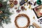 Preparing for Christmas or New Year holiday. Flat-lay of fur tree branches, wreaths, rope, scissors, craft paper over