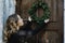 Preparing for Christmas. Young woman hanging wreath on door